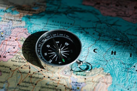 A compass resting on a map of China and India signifies exploration and adventure.