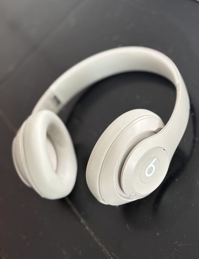 Light gray Beats Studio Pro headphones on a counter, showcasing why they are the best noise-canceling headphones for travel for quiet flights. Great way to extend the life of beats.