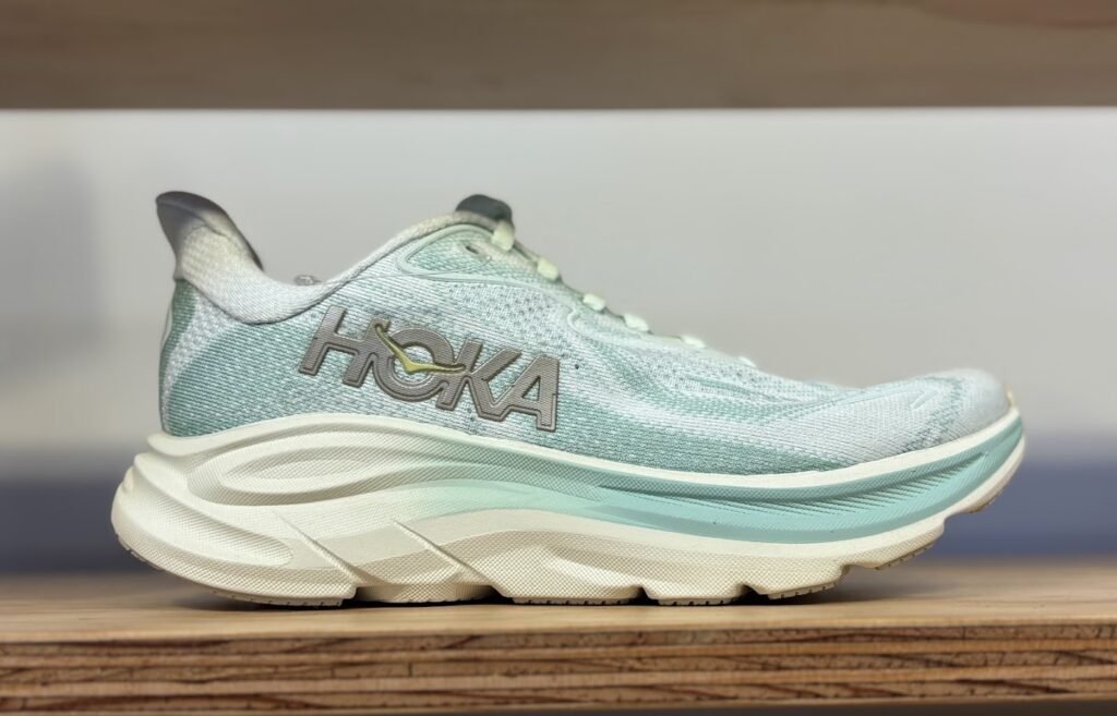 Side view of Seafoam Green Hoka Clifton 10 sneakers, featuring plush cushioning and a breathable knit upper, ideal as the best travel shoes for carry-on travel.
