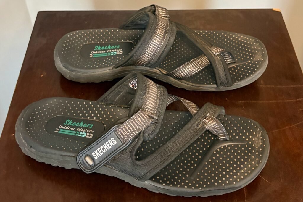 A well-worn pair of black Skechers Women's Reggae sandals, demonstrating excellent durability and proving they are the best travel sandals for women who walk many miles.