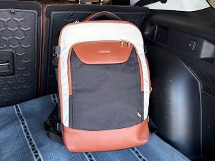 LOVELOOK 40L travel backpack placed on a car seat, showing compact personal item size that is Spirit and Frontier approved with a structured design and multiple compartments.