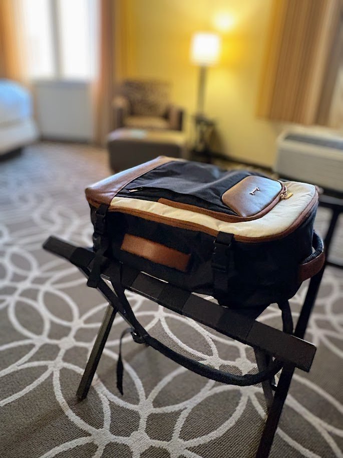 Lovelook 40L travel backpack sitting open on a luggage rack in a hotel room, ready for an overnight packing list check.