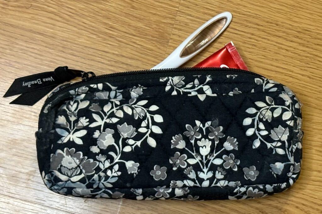 small black bag with toothbrush and tooth paste.