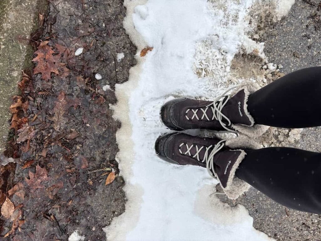 An overhead view of a small white personal cooler containing a Diet Dr Pepper can, two water bottles, and a blue ice pack.