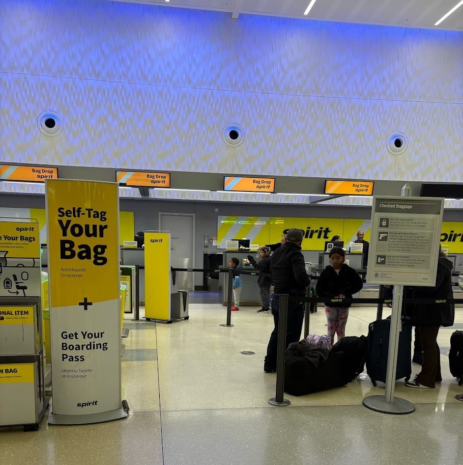 Spirit Airlines self-service bag tag and boarding pass kiosk at Orlando International Airport (MCO) terminal.