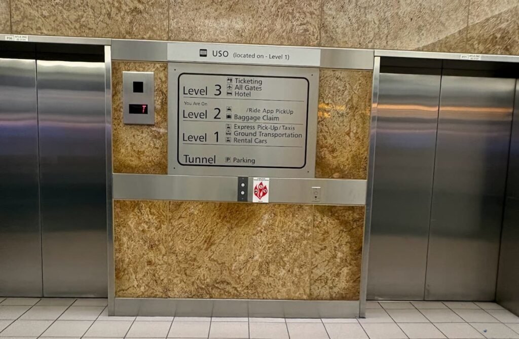 An elevator directory at Orlando International Airport (MCO) showing Level 1 for rental cars and ground transportation, Level 2 for baggage claim, and Level 3 for ticketing.
