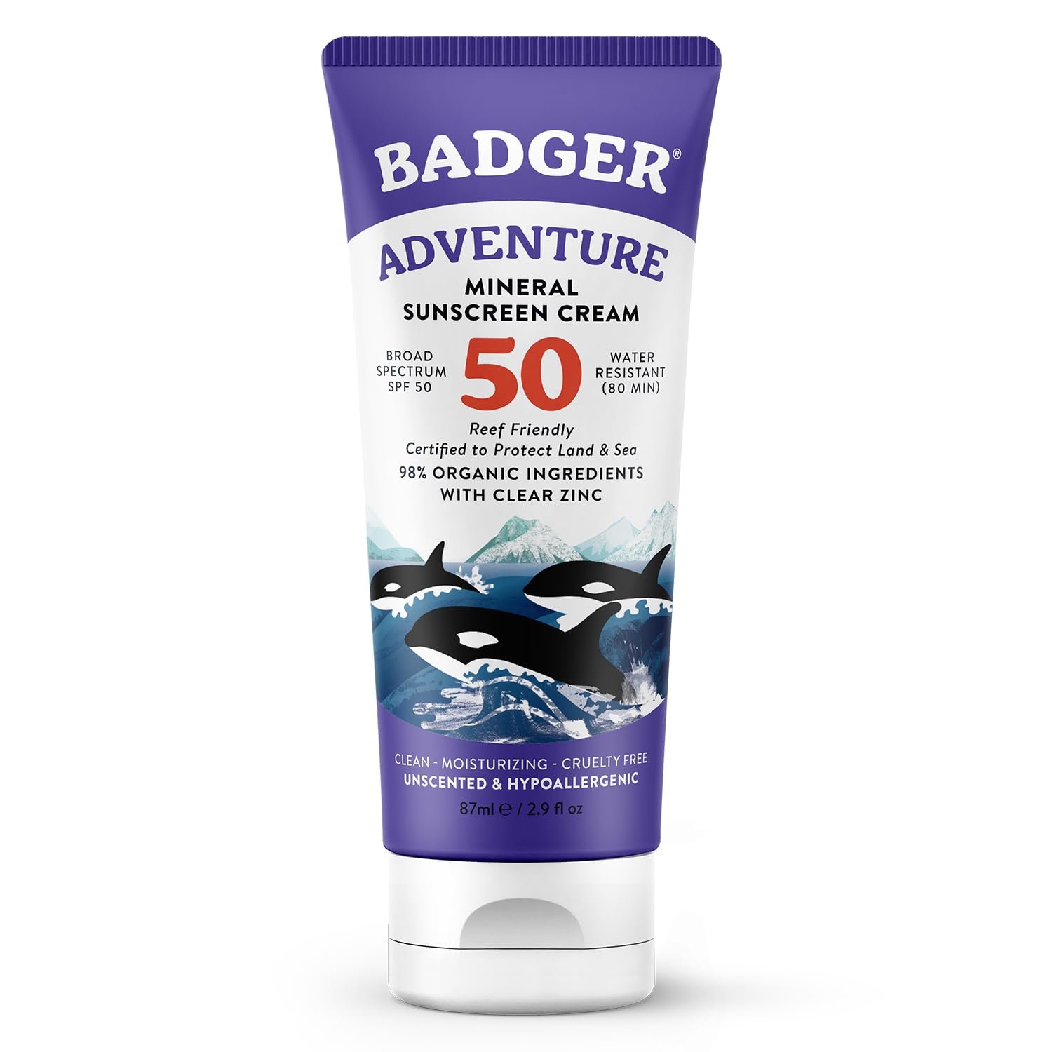 A vertical 2.9 fl oz tube of Badger Adventure Mineral Sunscreen Cream SPF 50. The tube is white with a purple cap and top, featuring an illustration of orcas jumping in front of snow-capped mountains. Text highlights include "98% Organic Ingredients," "Reef Friendly," and "Broad Spectrum SPF 50.