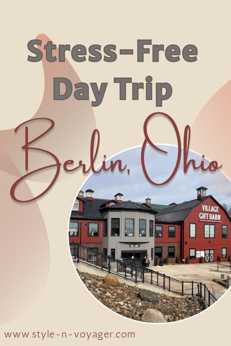 A blog feature image for a stress-free day trip to Berlin, Ohio. The graphic shows the red exterior of the Village Gift Barn with the text "Stress-Free Day Trip to Berlin, Ohio" on a tan background.