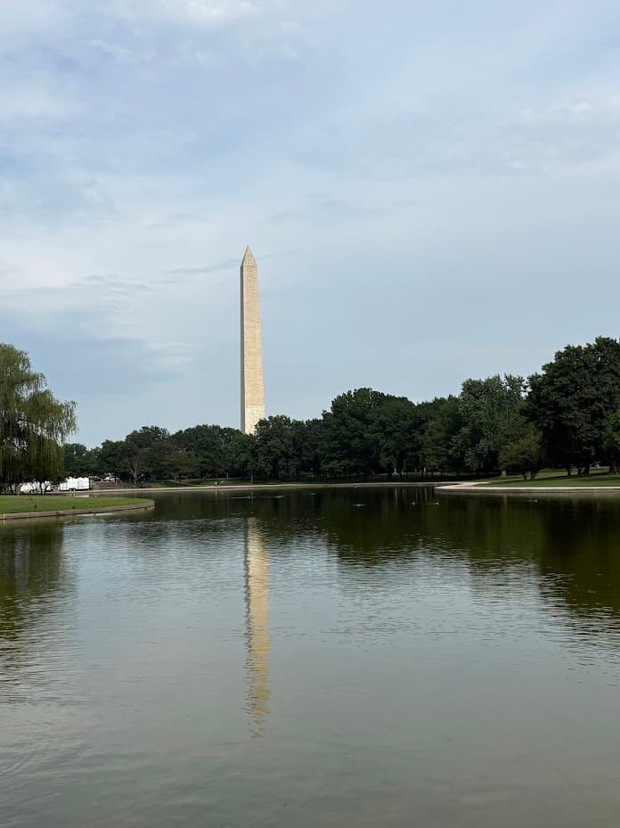 Vertical view of the Washington Monument and its clear reflection across the water of the Constitution Gardens Pond on a summer day in Washington, DC